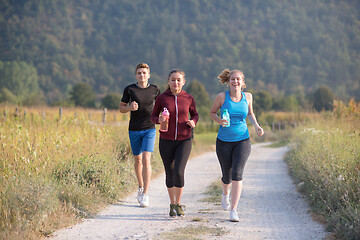 Image showing young people jogging on country road