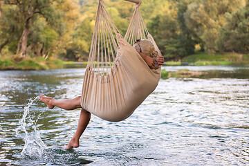 Image showing blonde woman resting on hammock