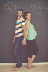 Image showing pregnant couple writing on a black chalkboard