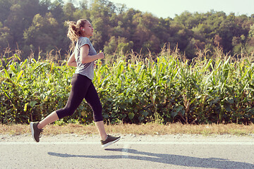 Image showing woman jogging along a country road