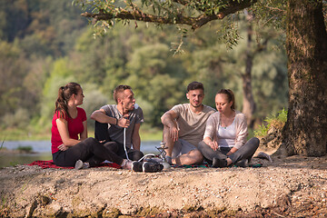 Image showing friends smoking hookah on the river bank