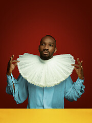 Image showing Young man as a medieval grandee on red background