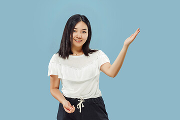 Image showing Korean young woman\'s half-length portrait on blue background