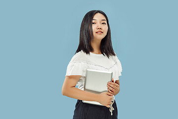 Image showing Korean young woman\'s half-length portrait on blue background