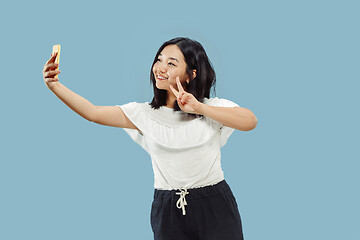 Image showing Korean young woman\'s half-length portrait on blue background