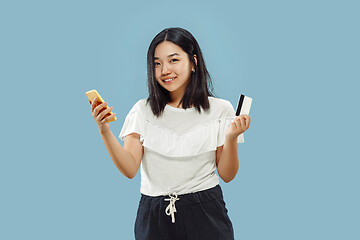 Image showing Korean young woman\'s half-length portrait on blue background