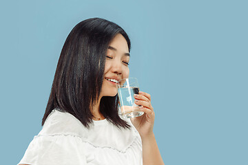 Image showing Korean young woman\'s half-length portrait on blue background