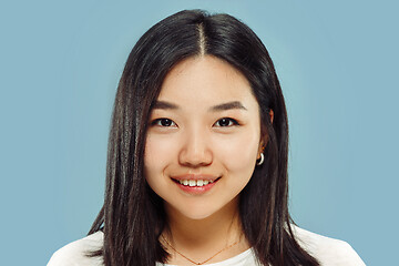 Image showing Korean young woman\'s close up portrait on blue background