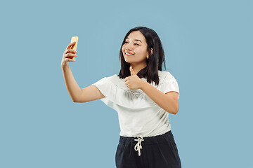 Image showing Korean young woman\'s half-length portrait on blue background