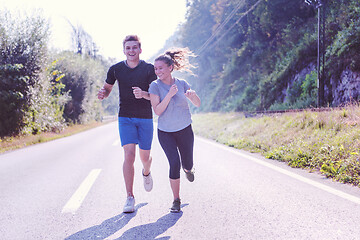 Image showing young couple jogging along a country road