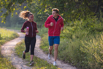 Image showing young couple jogging along a country road