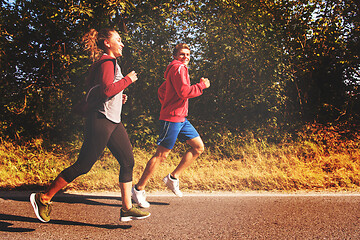 Image showing young couple jogging along a country road