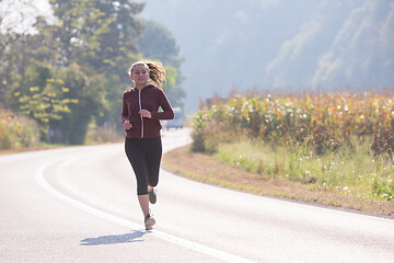 Image showing woman jogging along a country road