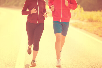 Image showing young couple jogging along a country road