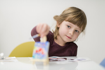 Image showing little girl painting on canvas