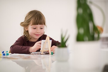 Image showing little girl painting on canvas