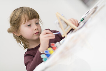 Image showing little girl painting on canvas