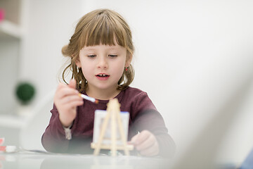 Image showing little girl painting on canvas