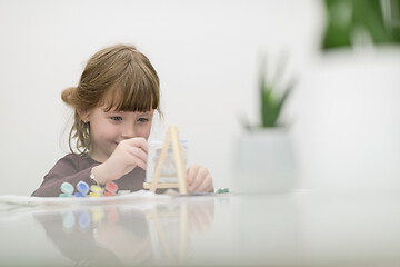 Image showing little girl painting on canvas