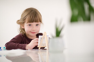 Image showing little girl painting on canvas