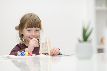 Image showing little girl painting on canvas