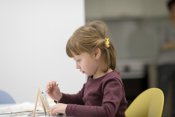 Image showing little girl painting on canvas