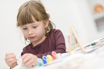 Image showing little girl painting on canvas