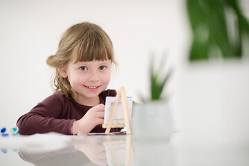 Image showing little girl painting on canvas