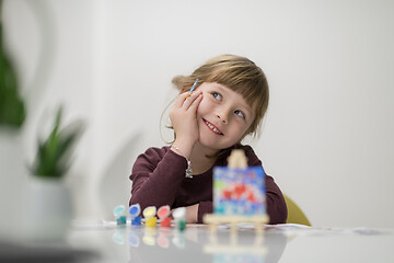 Image showing little girl painting on canvas