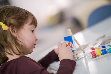 Image showing little girl painting on canvas