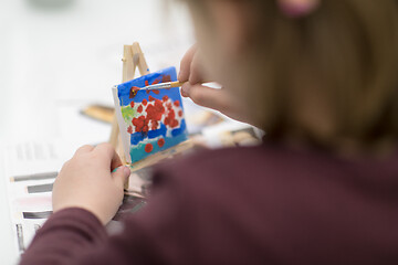 Image showing little girl painting on canvas