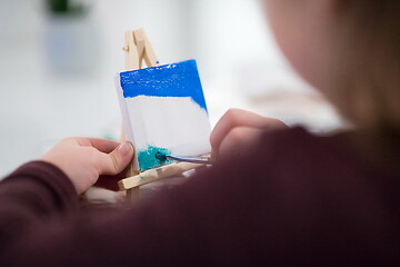 Image showing little girl painting on canvas