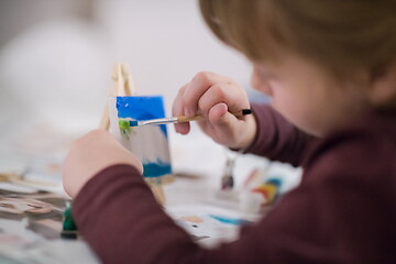 Image showing little girl painting on canvas