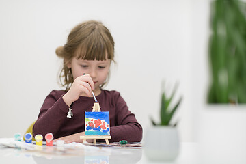 Image showing little girl painting on canvas