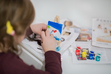 Image showing little girl painting on canvas