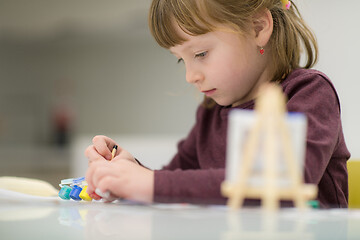 Image showing little girl painting on canvas