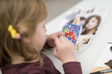 Image showing little girl painting on canvas