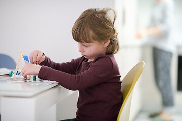 Image showing little girl painting on canvas