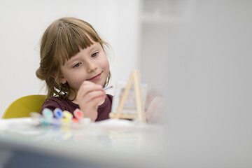 Image showing little girl painting on canvas