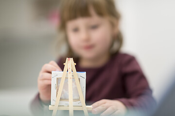 Image showing little girl painting on canvas