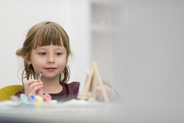 Image showing little girl painting on canvas