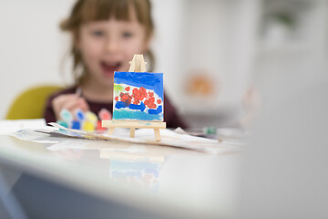 Image showing little girl painting on canvas