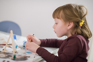 Image showing little girl painting on canvas