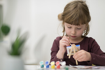 Image showing little girl painting on canvas