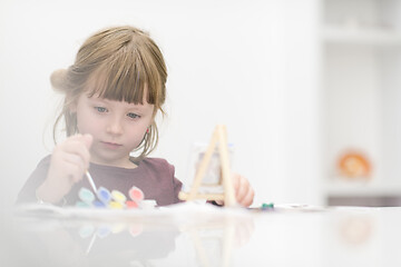 Image showing little girl painting on canvas