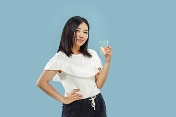 Image showing Korean young woman\'s half-length portrait on blue background