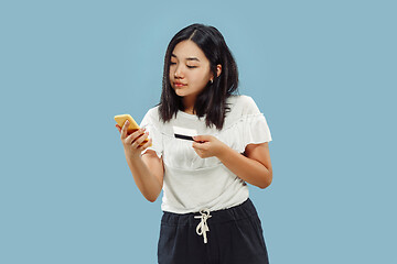 Image showing Korean young woman\'s half-length portrait on blue background