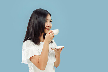 Image showing Korean young woman\'s half-length portrait on blue background