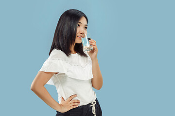 Image showing Korean young woman\'s half-length portrait on blue background