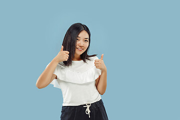 Image showing Korean young woman\'s half-length portrait on blue background